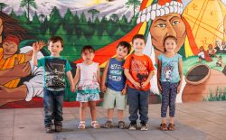 Niños frente a mural sobre Pueblos Originarios