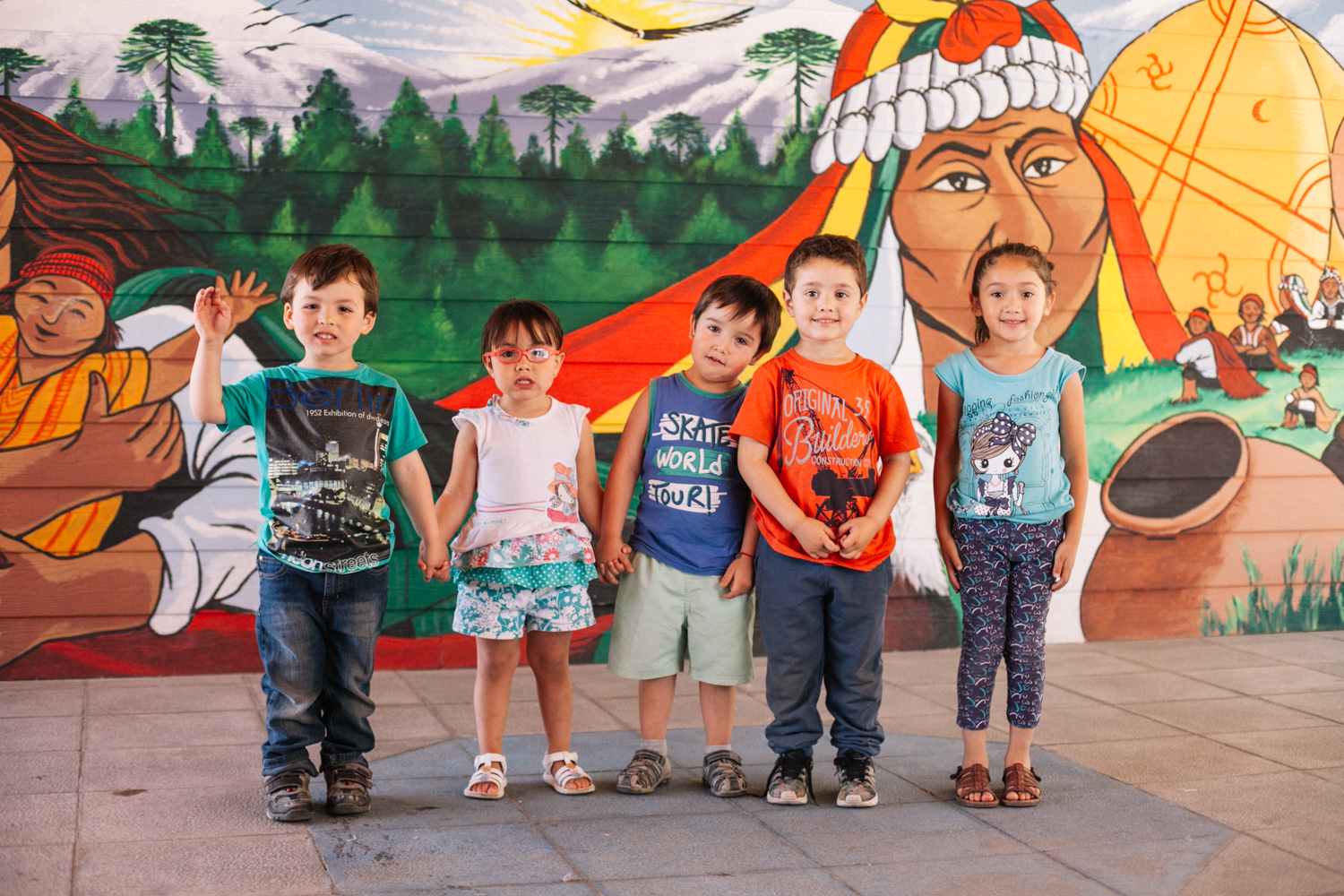 Niños frente a mural sobre Pueblos Originarios